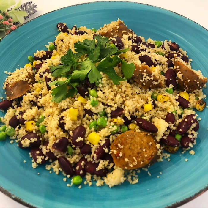 Couscous Plate with Kidney Beans, Peas, Grilled Corn, Plant Sausage, and Fresh Parsley