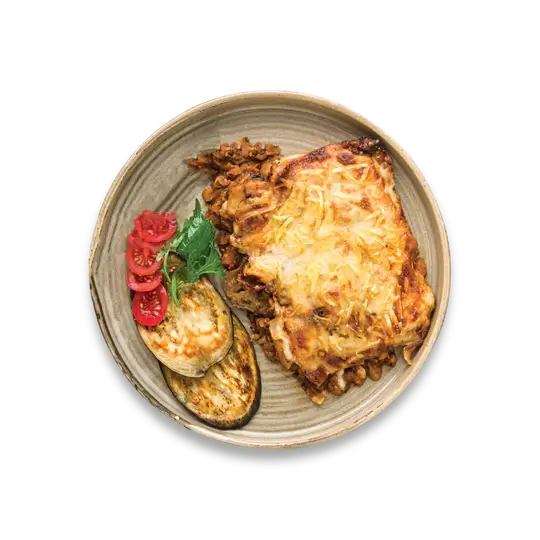 Vegan Moussaka. Delicious plant based ragu, seasoned with basil and mint, served between layers of aubergine and potato slices , topped with a moreish soya milk and cashew nut béchamel sauce, and finished with vegan cheese.